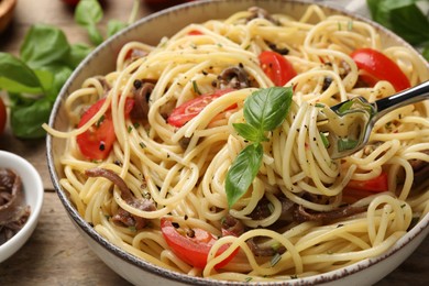 Photo of Delicious pasta with anchovies, tomatoes and spices on table, closeup