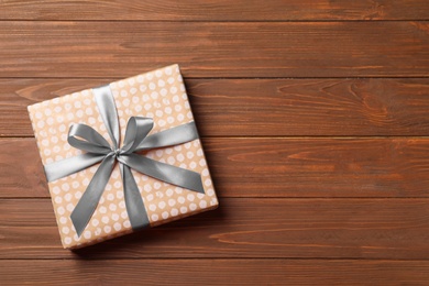 Beautiful gift box on wooden background, top view