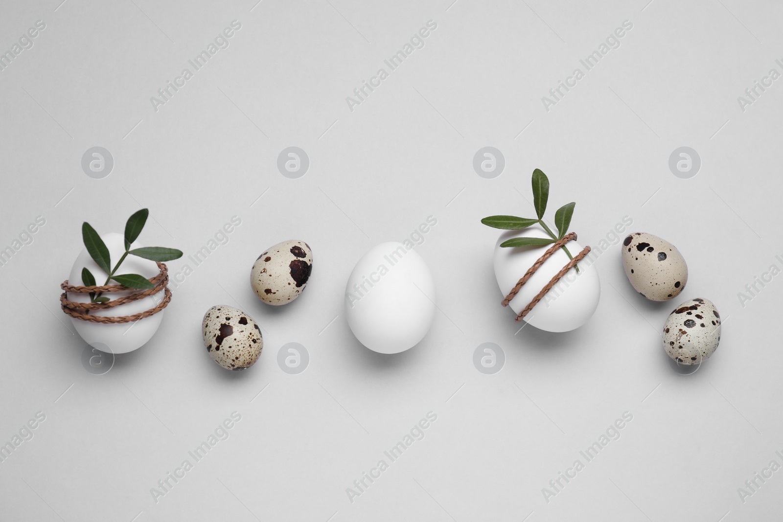 Photo of Beautifully decorated Easter eggs on light grey background, flat lay