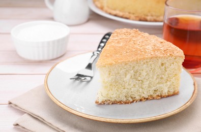 Photo of Piece of tasty sponge cake on white table, closeup