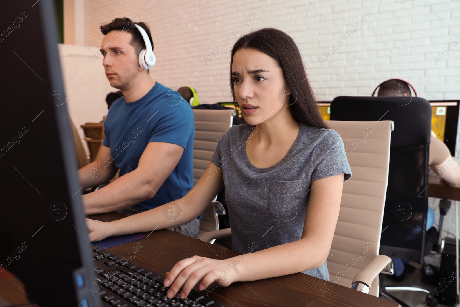 Photo of Young people playing video games on computers indoors. Esports tournament