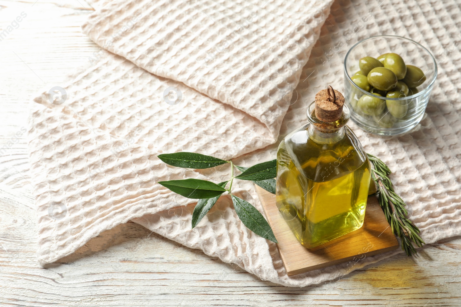 Photo of Bottle with fresh olive oil on table