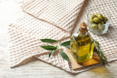 Bottle with fresh olive oil on table