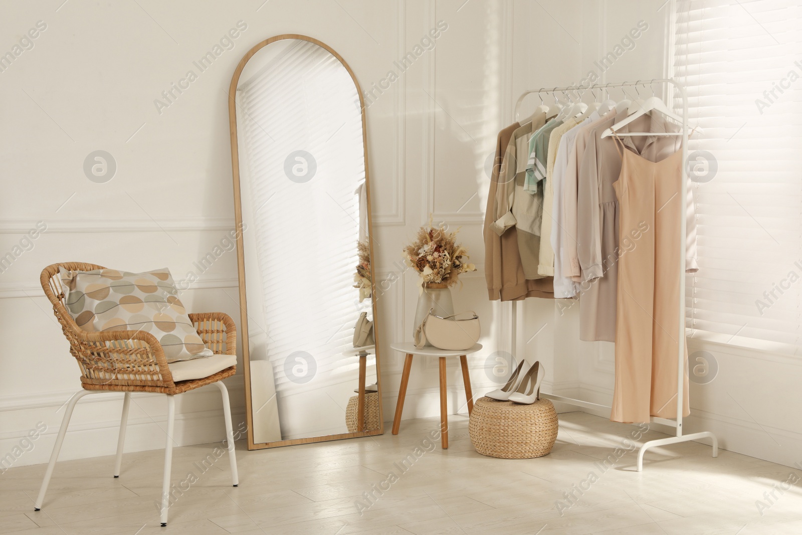 Photo of Modern dressing room interior with stylish clothes, shoes and beautiful dry flowers