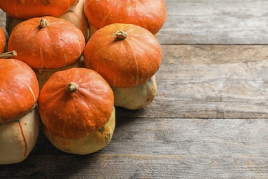 Photo of Orange pumpkins with space for text on wooden table. Autumn holidays