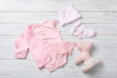 Photo of Flat lay composition with stylish baby clothes on wooden background