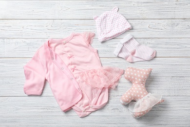 Flat lay composition with stylish baby clothes on wooden background