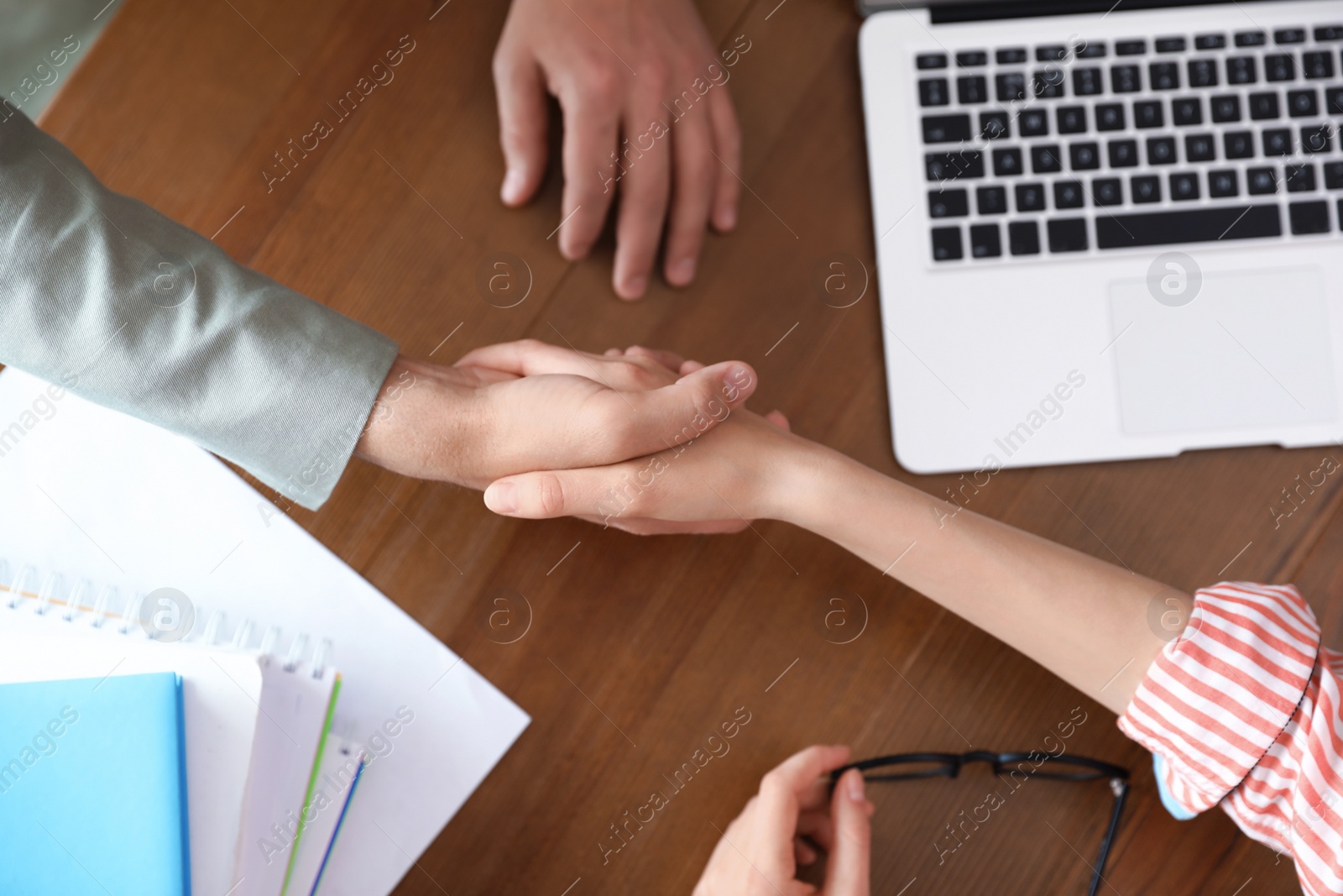 Photo of Business partners shaking hands at table after meeting, top view