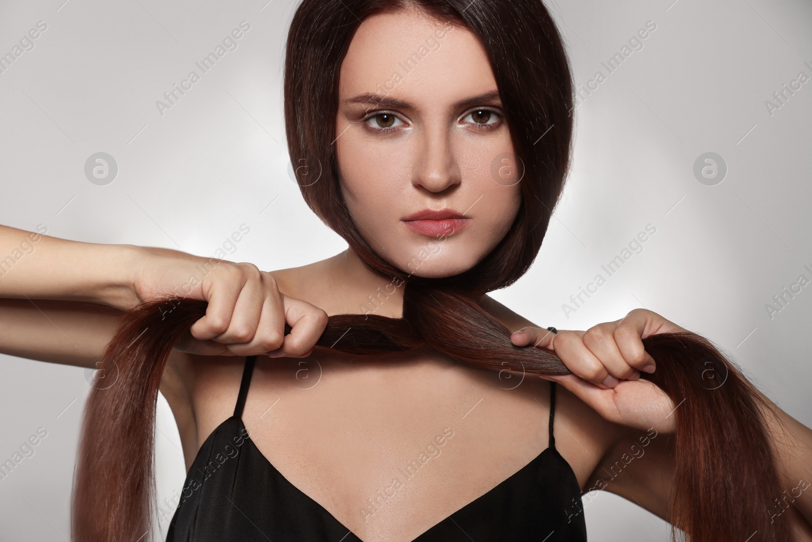 Photo of Beautiful young woman with healthy strong hair posing in studio