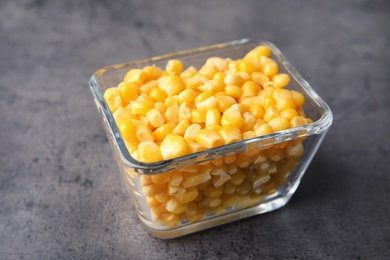 Photo of Bowl with corn kernels on grey background