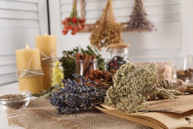 Photo of Different dry herbs and flowers on white table