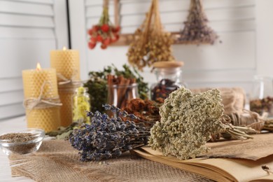 Different dry herbs and flowers on white table