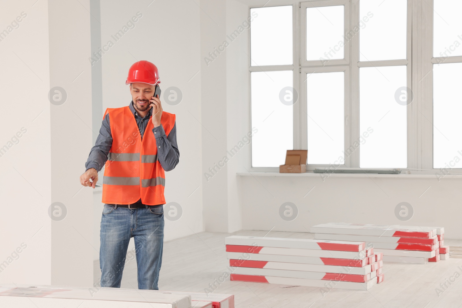 Photo of Male industrial engineer in uniform talking on phone indoors