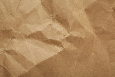 Photo of Crumpled kraft notebook sheet as background, top view
