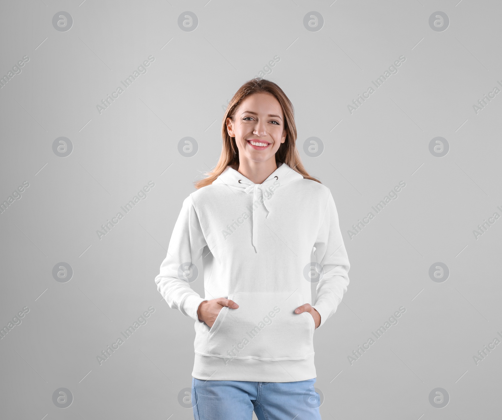 Photo of Portrait of woman in hoodie sweater on light background. Space for design