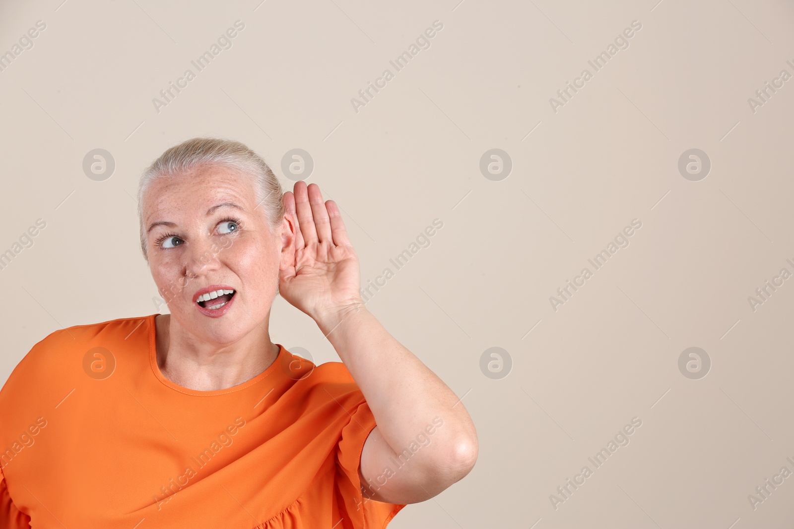 Photo of Mature woman with hearing problem on light background. Space for text