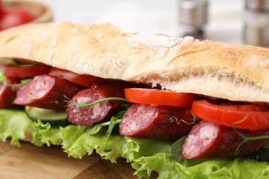 Photo of Delicious sandwich with sausages and vegetables on table, closeup