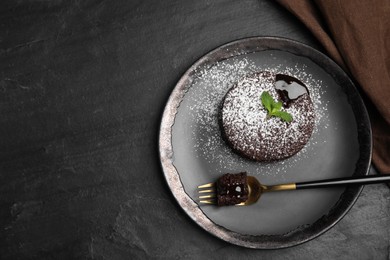 Photo of Delicious fresh fondant with hot chocolate and mint on black table, top view. Space for text