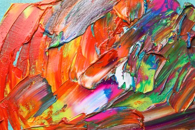 Photo of Strokes of colorful acrylic paints as background, closeup view