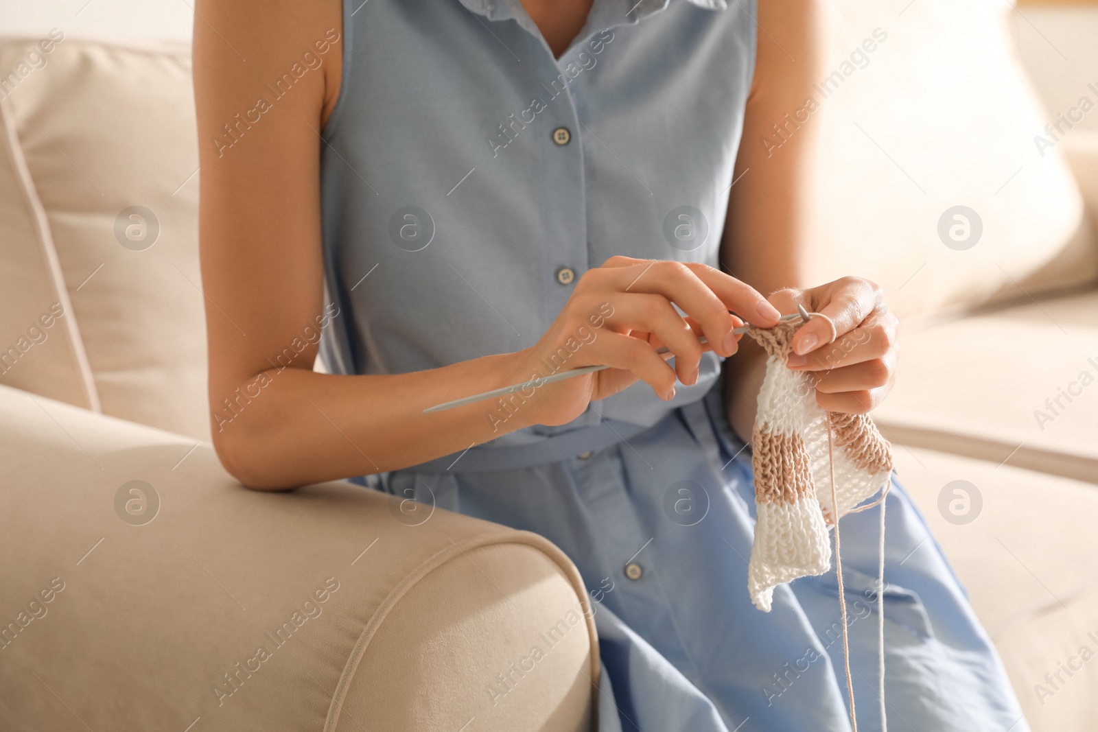 Photo of Young woman knitting with needles at home, closeup. Handicraft as hobby