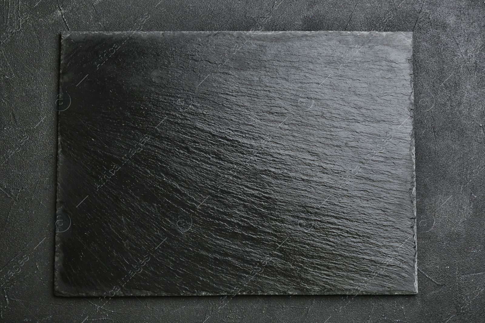 Photo of Black textured slate board on dark background