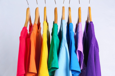 Photo of Colorful clothes on hangers against white background