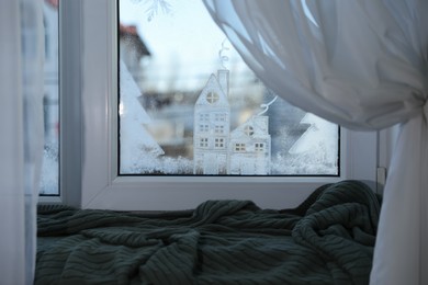 Photo of Beautiful drawing made of artificial snow on window at home. Christmas decor