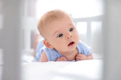 Photo of Cute little baby lying in crib at home