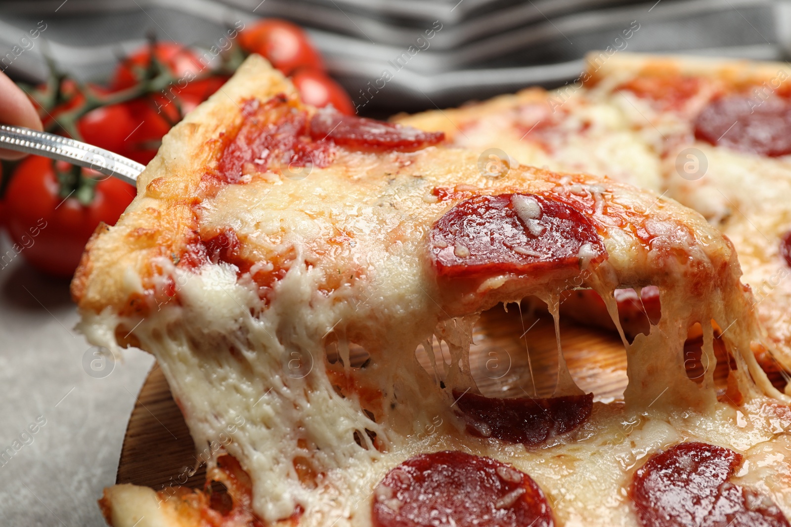 Photo of Taking slice of tasty pepperoni pizza on table, closeup