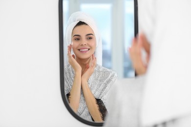 Photo of Beautiful happy woman in stylish bathrobe near mirror in bathroom