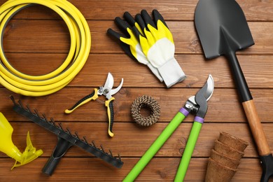 Flat lay composition with gardening tools on wooden background