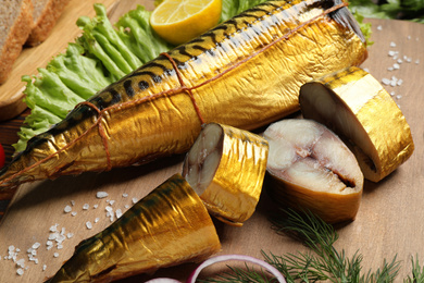 Photo of Tasty smoked fish on wooden table, closeup