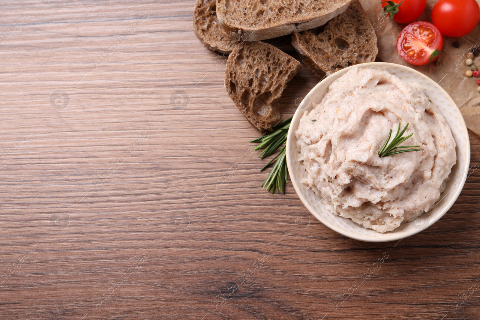 Photo of Delicious lard spread in bowl on wooden table, flat lay. Space for text