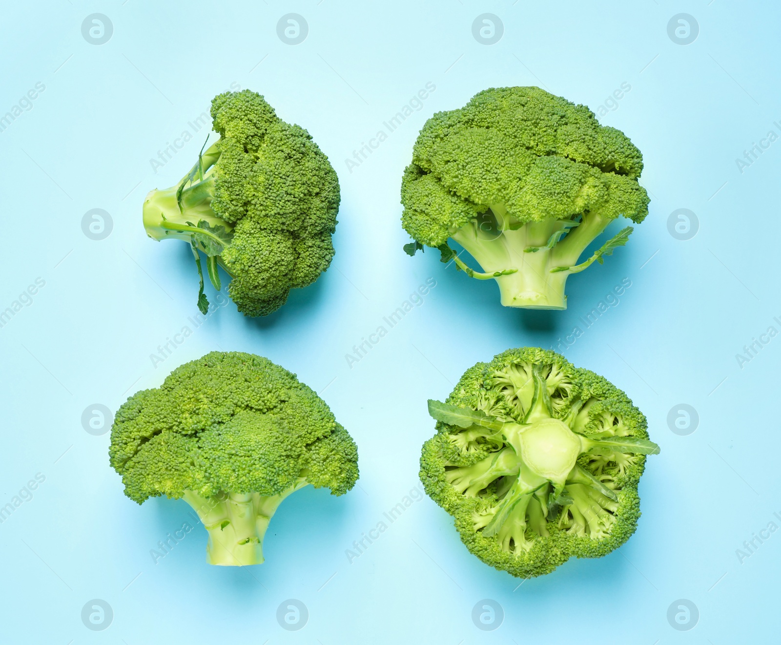 Photo of Fresh tasty broccoli on light blue background, flat lay