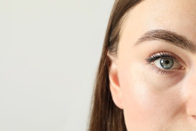 Photo of Closeup photo of woman with beautiful eyes on light background. Space for text