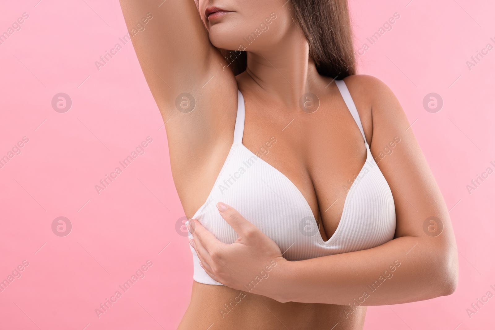 Photo of Woman with beautiful breast on pink background, closeup