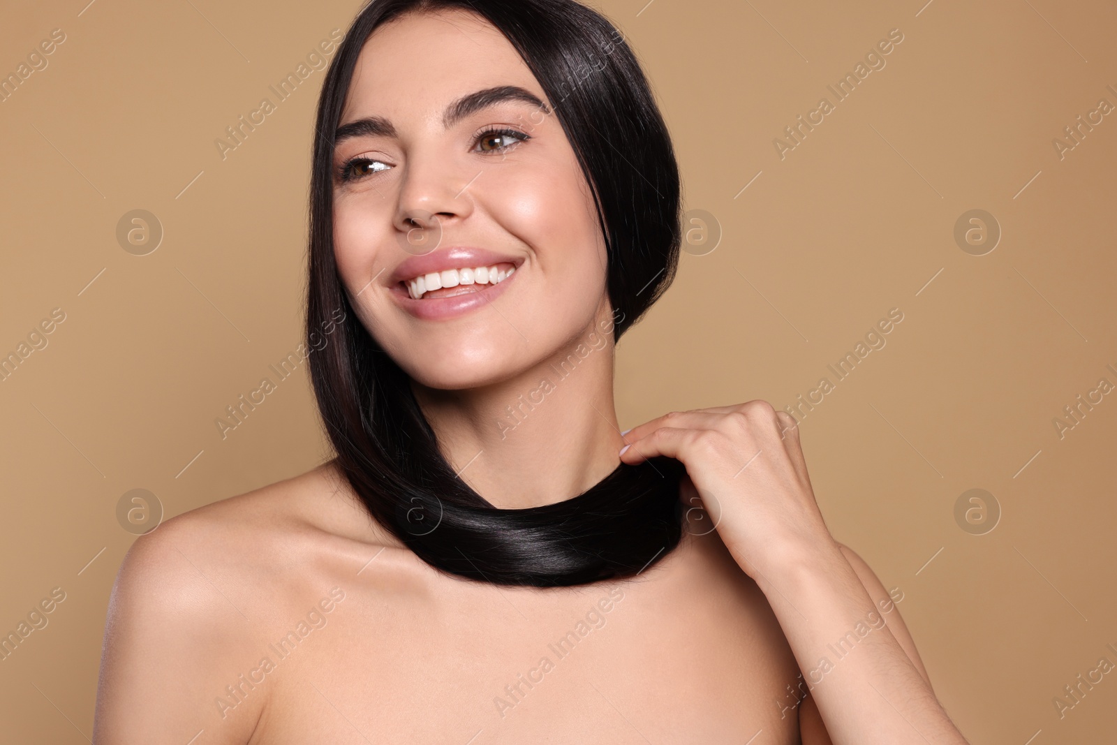 Photo of Portrait of beautiful young woman with healthy strong hair on beige background