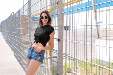 Photo of Young woman wearing black t-shirt on street. Urban style