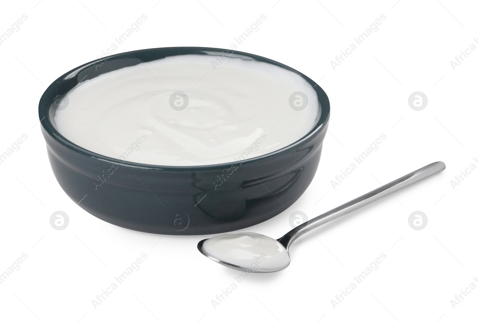 Photo of Bowl and spoon with delicious organic yogurt on white background