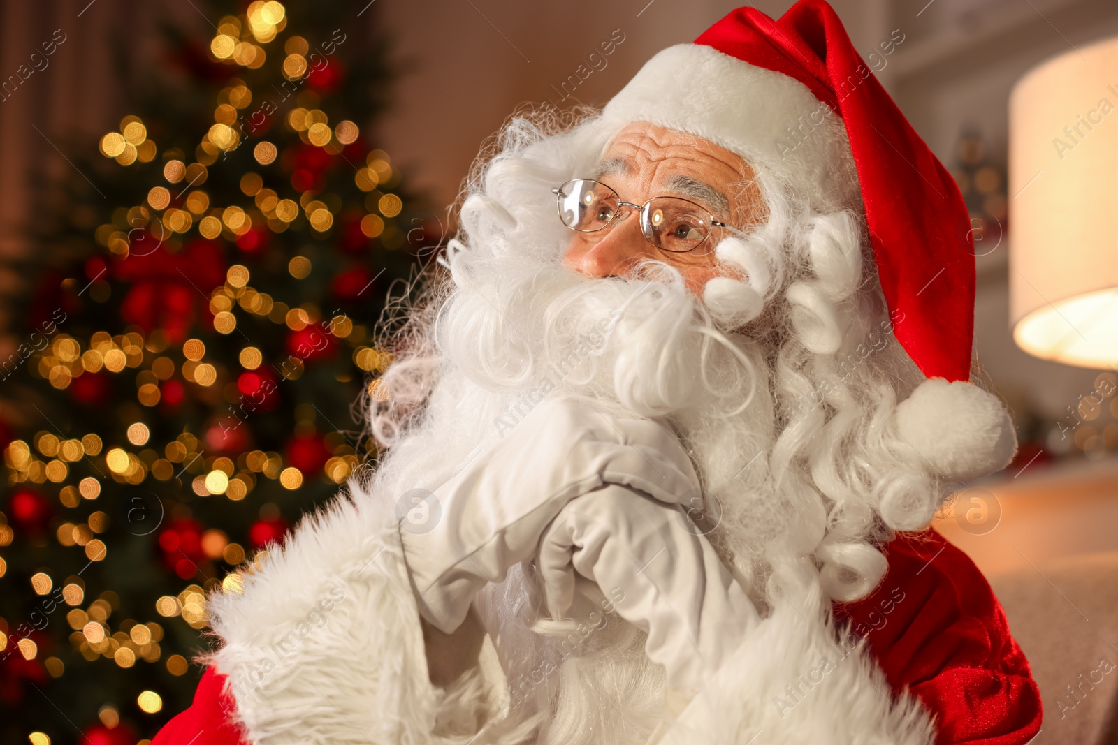 Photo of Santa Claus in room with Christmas tree