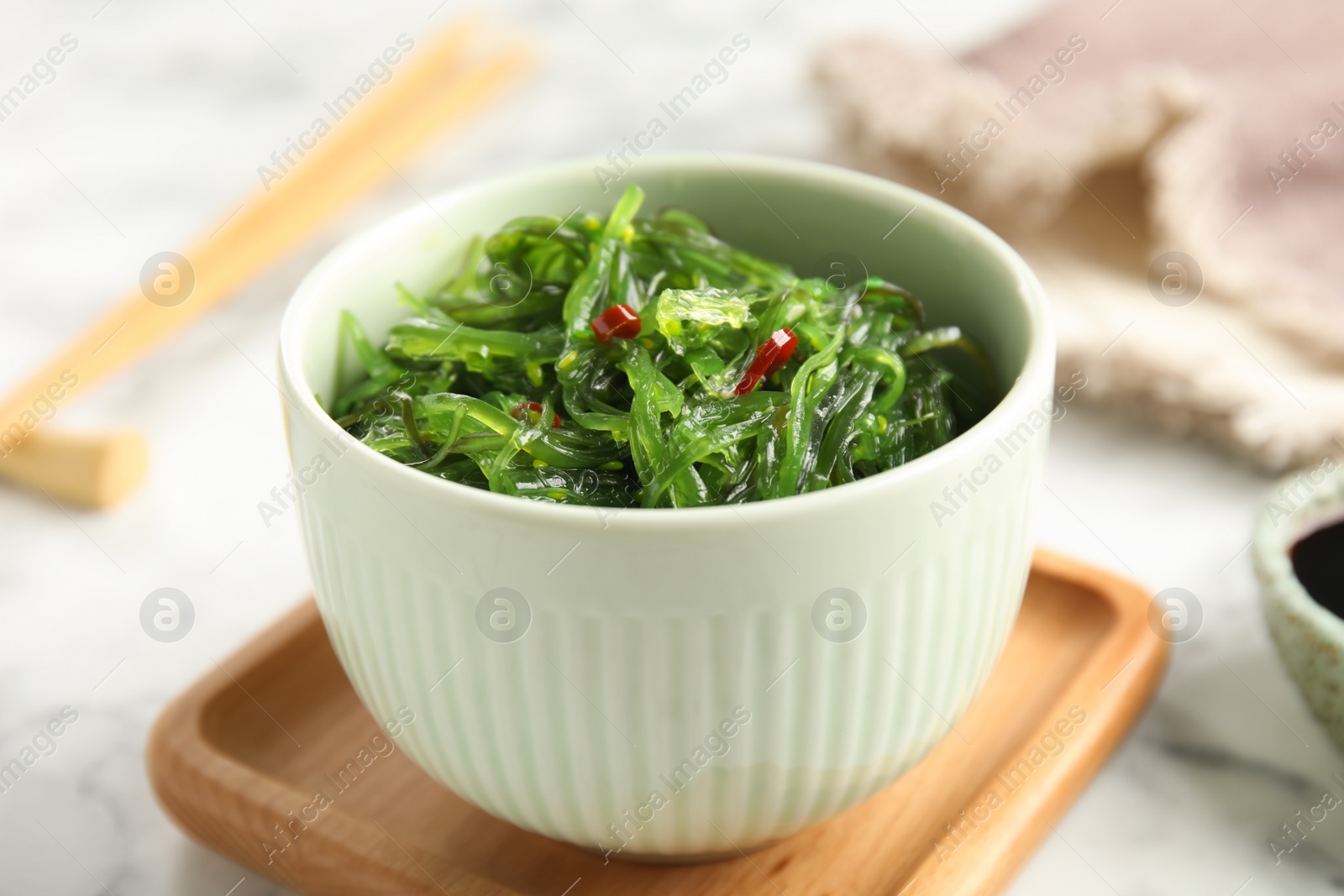 Photo of Japanese seaweed salad served on table, closeup