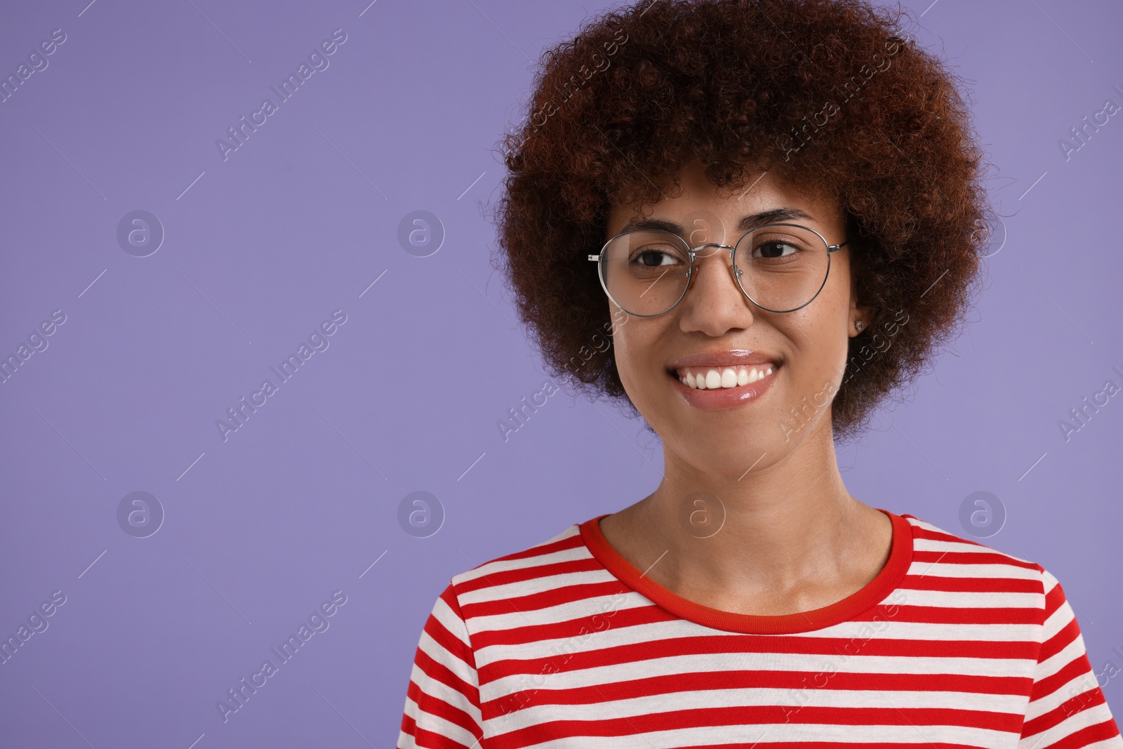 Photo of Portrait of happy young woman in eyeglasses on purple background. Space for text