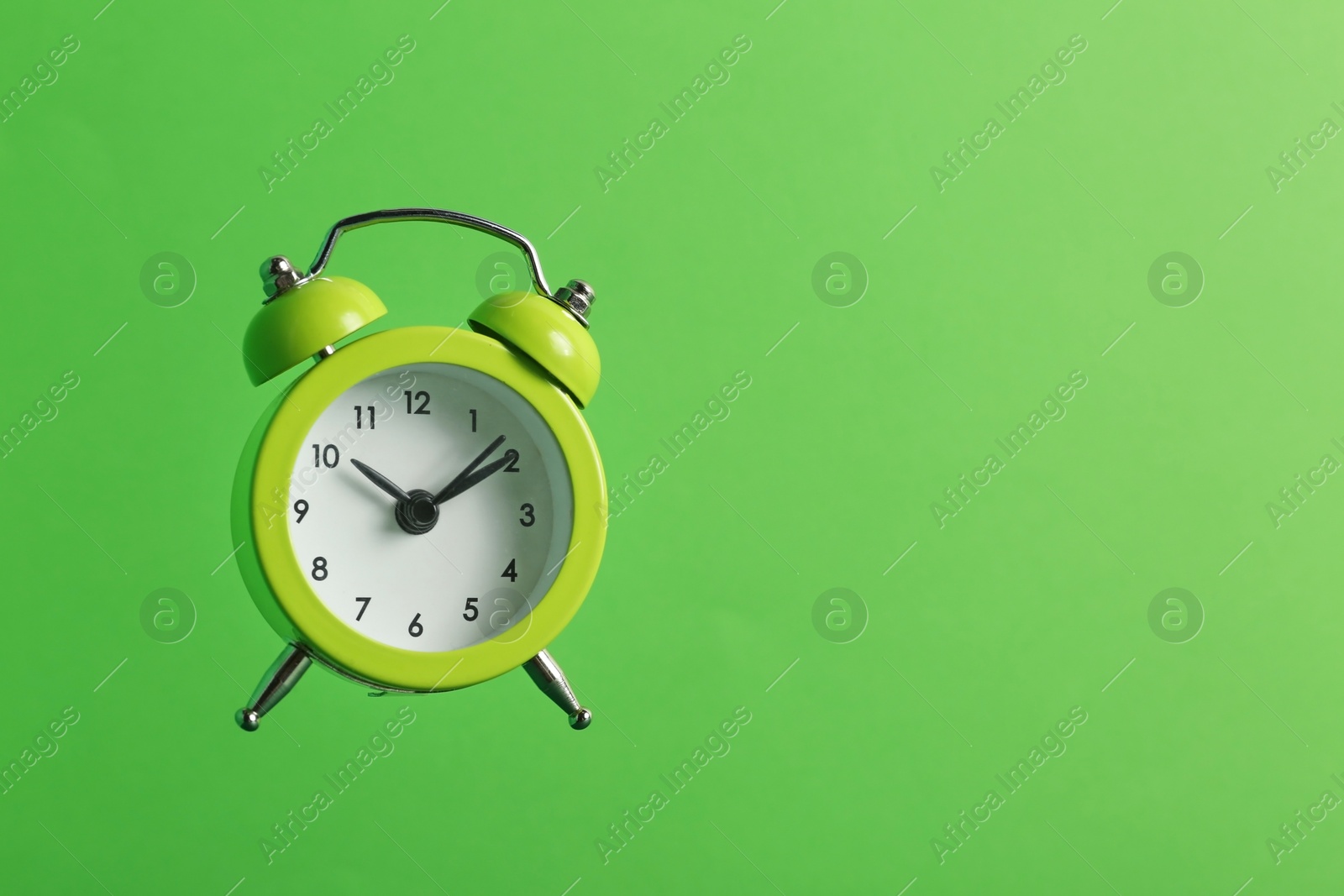 Photo of Alarm clock on green background. Space for text