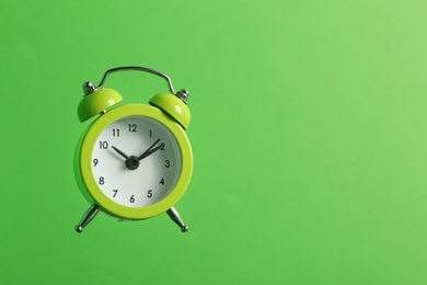 Photo of Alarm clock on green background. Space for text