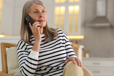 Photo of Senior woman talking on phone at home, space for text