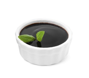 Balsamic glaze with basil leaves in bowl isolated on white