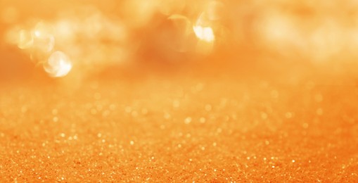 Image of Shiny orange glitter and blurred lights on background, banner design. Bokeh effect