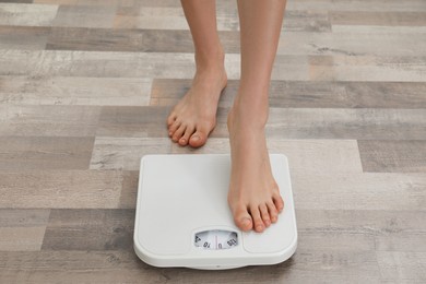 Photo of Woman stepping on floor scales, closeup. Weight control
