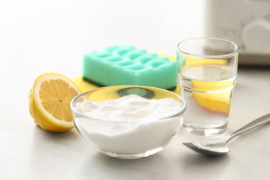 Photo of Baking soda, lemon and vinegar on light stone table. Eco friendly detergents