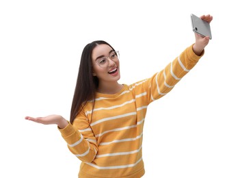 Smiling young woman taking selfie with smartphone on white background